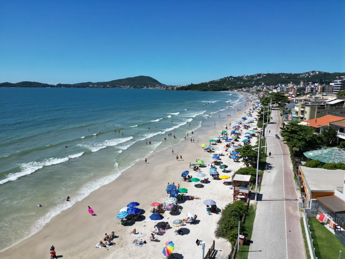 Praia de Bombas com guarda-sóis em dia ensolarado